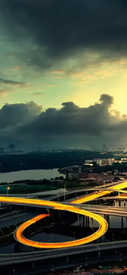 Hero background image of stormy sky and long exposure headlights on freeway.